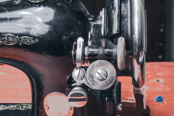 A sewing vintage mechanical machine is stored on a shelf.