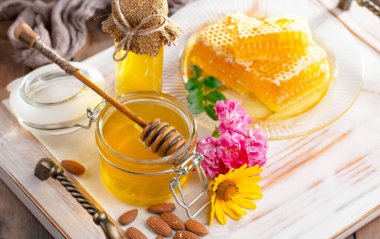 Arı balı kavanozda, çiçekli, eski arka planda..