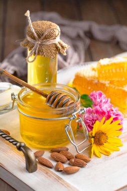 Arı balı kavanozda, çiçekli, eski arka planda..
