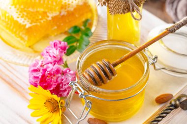 Arı balı kavanozda, çiçekli, eski arka planda..