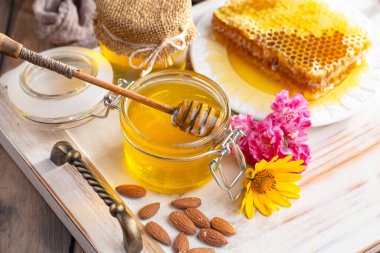 Arı balı kavanozda, çiçekli, eski arka planda..