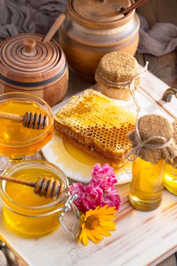 Arı balı kavanozda, çiçekli, eski arka planda..