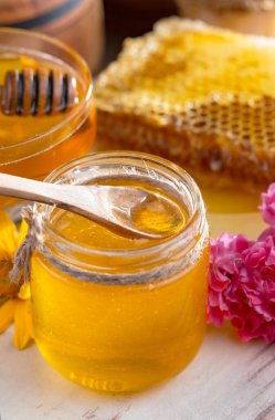 Arı balı kavanozda, çiçekli, eski arka planda..