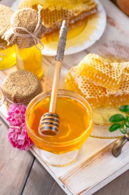 Arı balı kavanozda, çiçekli, eski arka planda..
