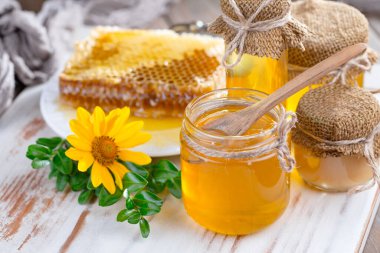 Arı balı kavanozda, çiçekli, eski arka planda..