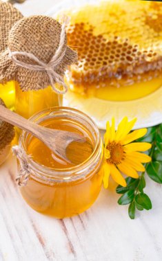 Arı balı kavanozda, çiçekli, eski arka planda..