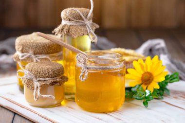 Arı balı kavanozda, çiçekli, eski arka planda..