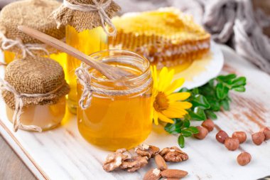 Arı balı kavanozda, çiçekli, eski arka planda..