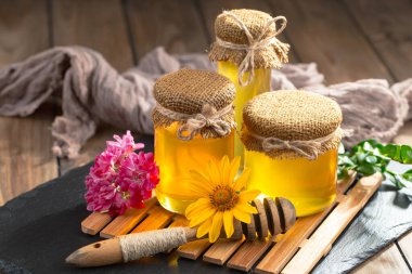 Arı balı kavanozda, çiçekli, eski arka planda..