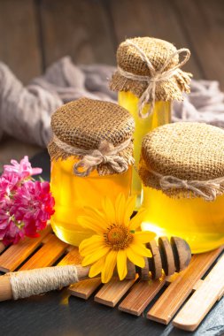 Arı balı kavanozda, çiçekli, eski arka planda..