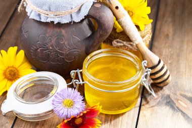 Arı balı kavanozda, çiçekli, eski arka planda..