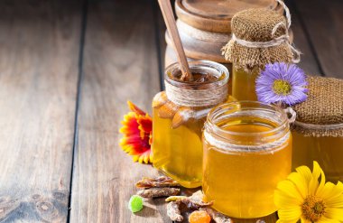 Arı balı kavanozda, çiçekli, eski arka planda..