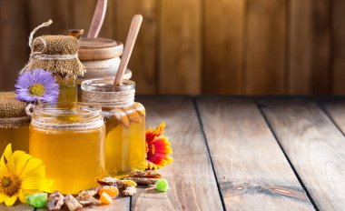 Arı balı kavanozda, çiçekli, eski arka planda..