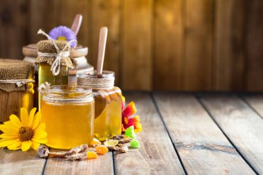 Arı balı kavanozda, çiçekli, eski arka planda..