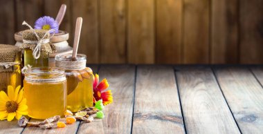 Arı balı kavanozda, çiçekli, eski arka planda..