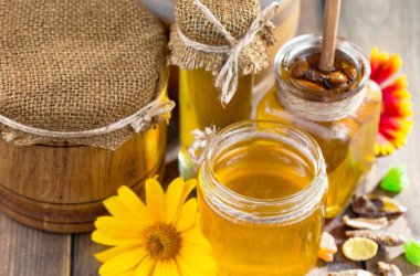 Arı balı kavanozda, çiçekli, eski arka planda..