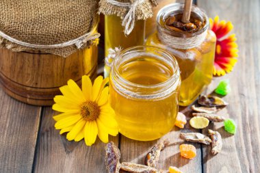 Arı balı kavanozda, çiçekli, eski arka planda..