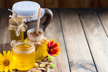 Arı balı kavanozda, çiçekli, eski arka planda..