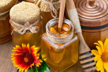 Arı balı kavanozda, çiçekli, eski arka planda..