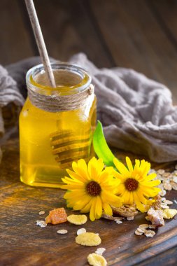 Arı balı kavanozda, çiçekli, eski arka planda..