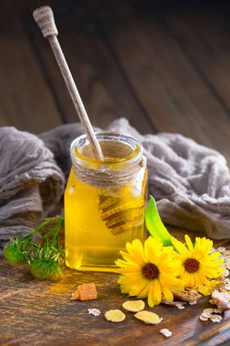 Arı balı kavanozda, çiçekli, eski arka planda..