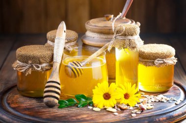 Arı balı kavanozda, çiçekli, eski arka planda..