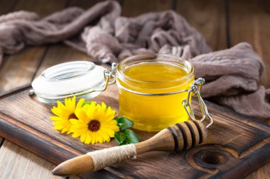 Arı balı kavanozda, çiçekli, eski arka planda..