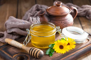 Arı balı kavanozda, çiçekli, eski arka planda..