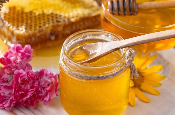 古い背景に花のある瓶の中の蜂の蜂蜜 — ストック写真