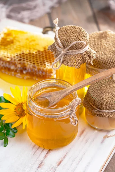 蜜蜂蜂蜜在一个有花的罐子里 在旧的背景上 — 图库照片