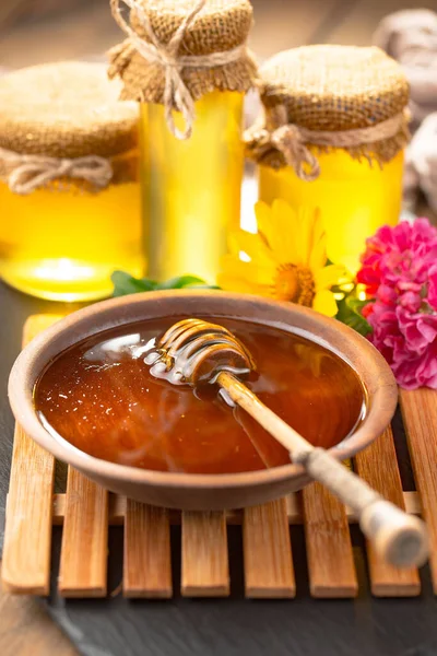 Arı balı kavanozda, çiçekli, eski arka planda..