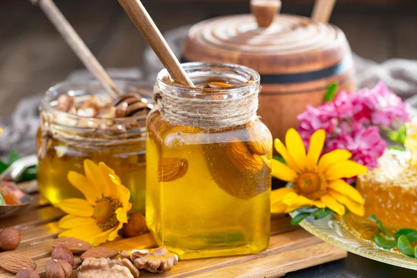 The honey flows slowly from the stick onto the honeycomb.