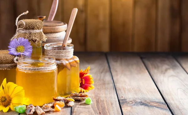 Arı balı kavanozda, çiçekli, eski arka planda..