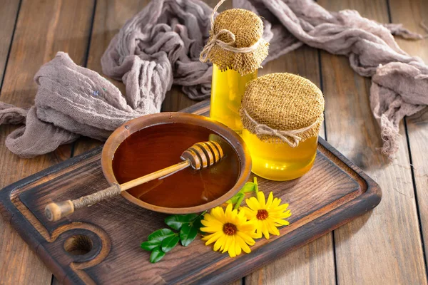 Arı balı kavanozda, çiçekli, eski arka planda..