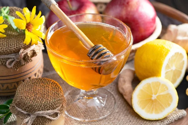 The honey flows slowly from the stick onto the honeycomb.