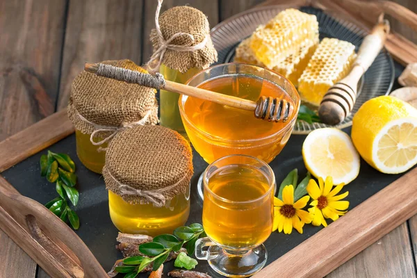 The honey flows slowly from the stick onto the honeycomb.