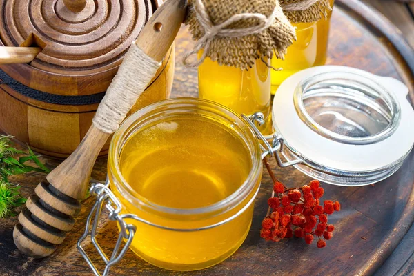 The honey flows slowly from the stick onto the honeycomb.