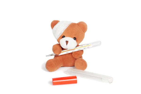 Urso de pelúcia com bandagem e termômetro em branco — Fotografia de Stock