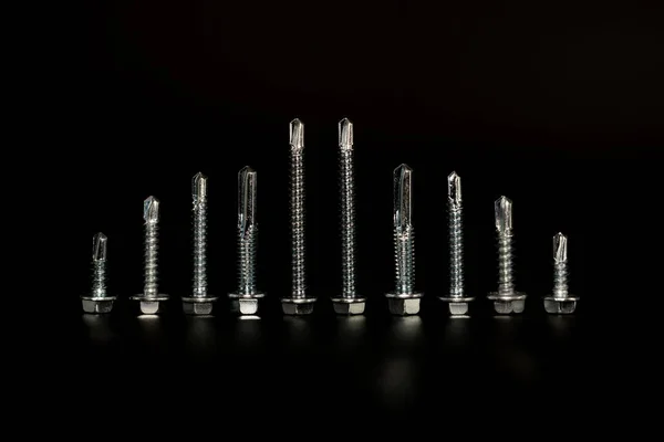 Screws on black background — Stock Photo, Image