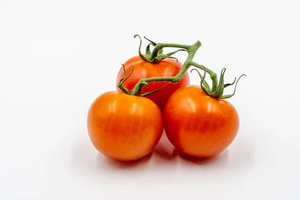 Três tomates vermelhos com ramo — Fotografia de Stock