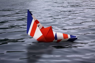 Su - Avrupa Birliği ve ekonominin bırakarak İngiltere'de gösterilen ve İngiltere'de boğulma - fotoğraf manipülasyon kavramı batan İngiliz bayrağı olarak yapılan kağıt tekne