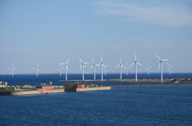 Karada ve suda rüzgar türbinleri alternatif sürdürülebilir enerji yaratıyor. Mavi gökyüzü ve boşluğu kopyalayan peyzaj