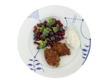 Vejetaryen yemekleri. Kırmızı mercimek, soğan, maydanoz ve yulaf ezmesinden sebze pirzola. Brokoli salatası, nar tohumu, yaban mersini ve süzme peynir ile. Üstte yalıtılmış görünüm.