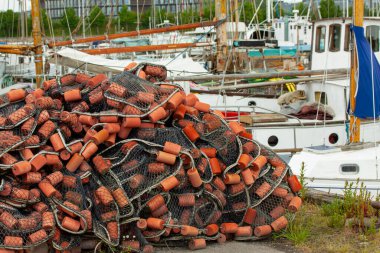 Limanda yüzen balıkçı ağları ve arka planda balıkçı tekneleri..