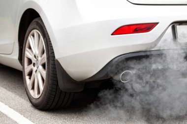 Exhaust pipe of a car - blowing out the pollution from the back of a white car. clipart