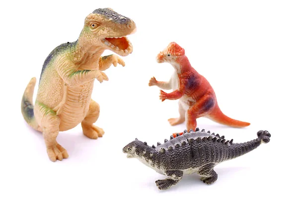 Bebek oyuncakları. Üç dinozor, beyaz arka planda izole edilmiş.