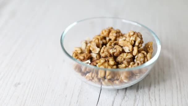 Pila Nueces Sin Cáscara Verter Tazón Vidrio Sobre Fondo Madera — Vídeo de stock