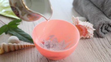 kozmetolojist bir kasede aljinat maskesi karıştırma. Cilt aydınlatma, nemlendirici, beslenme, anti-recuperative etkisi gençleştirme, cilt sıkılaştırma