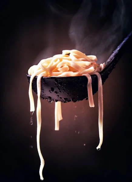 Dampfend Gekochte Fettuccine Pasta Auf Schwarzem Löffel Und Dunklem Hintergrund Stockfoto