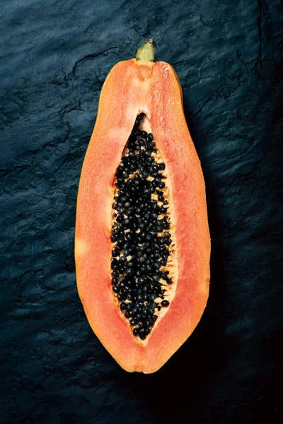 Papaya Pfotenpfote Zwei Hälften Geschnitten Und Von Oben Auf Dunkelblauem lizenzfreie Stockbilder